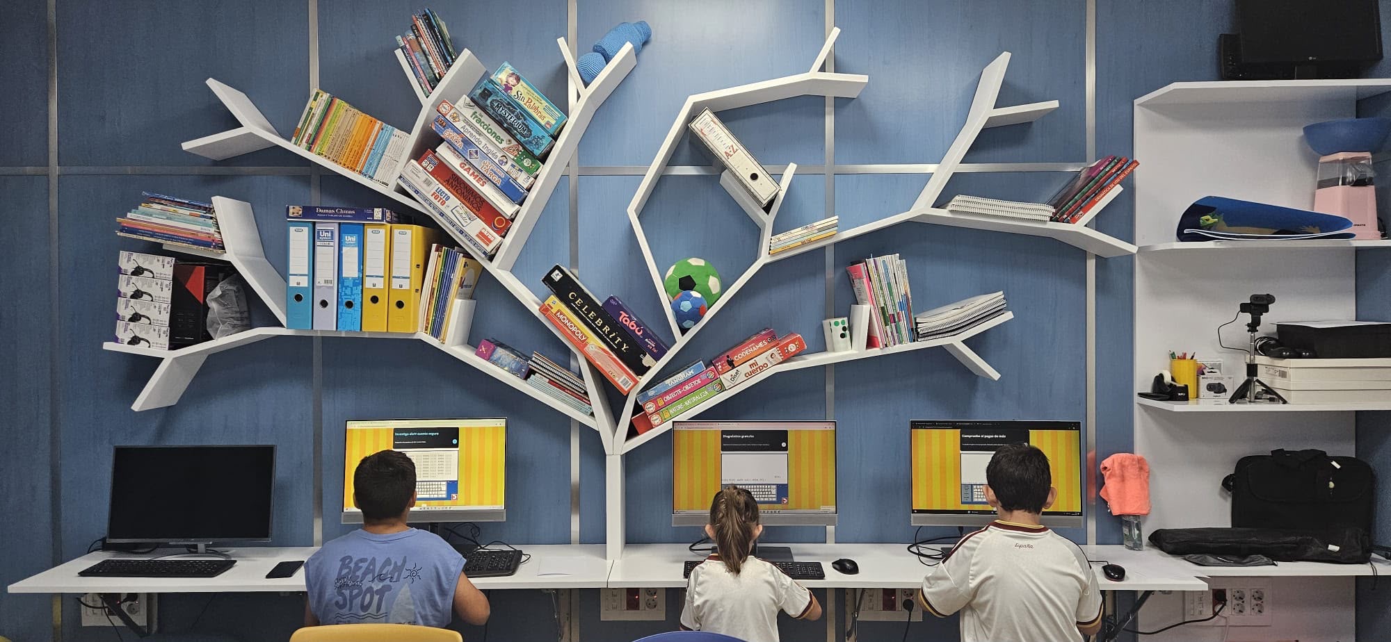 Zona de estudio de DIDAL con la estantería en forma de árbol y los puestos de ordenador